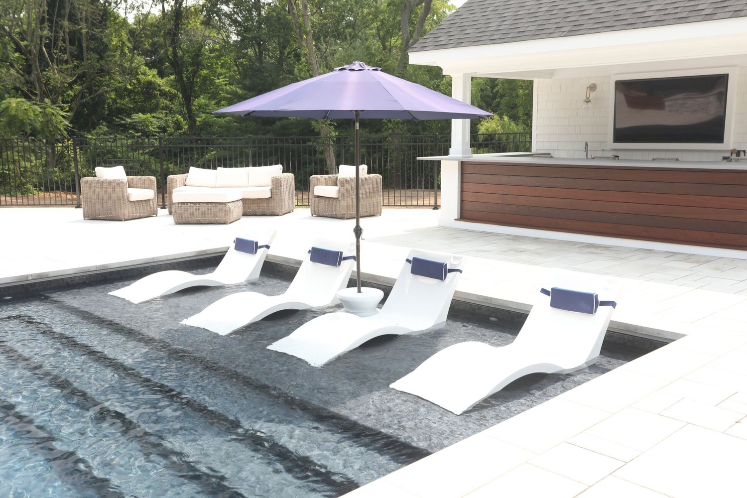 Sun shelf with white loungers beside a modern cabana